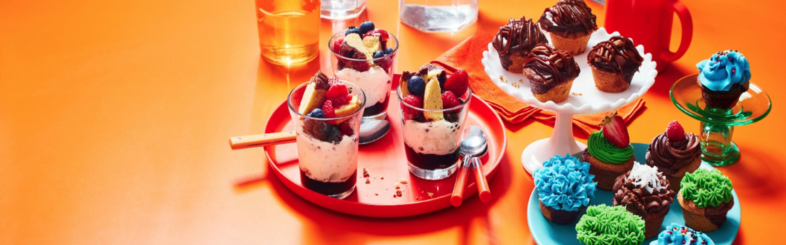 Coupe de bagatelle et de madeleine au brownie, madeleine au brownie et au caramel, et petits gâteaux aux madeleines au brownie sur fond orange