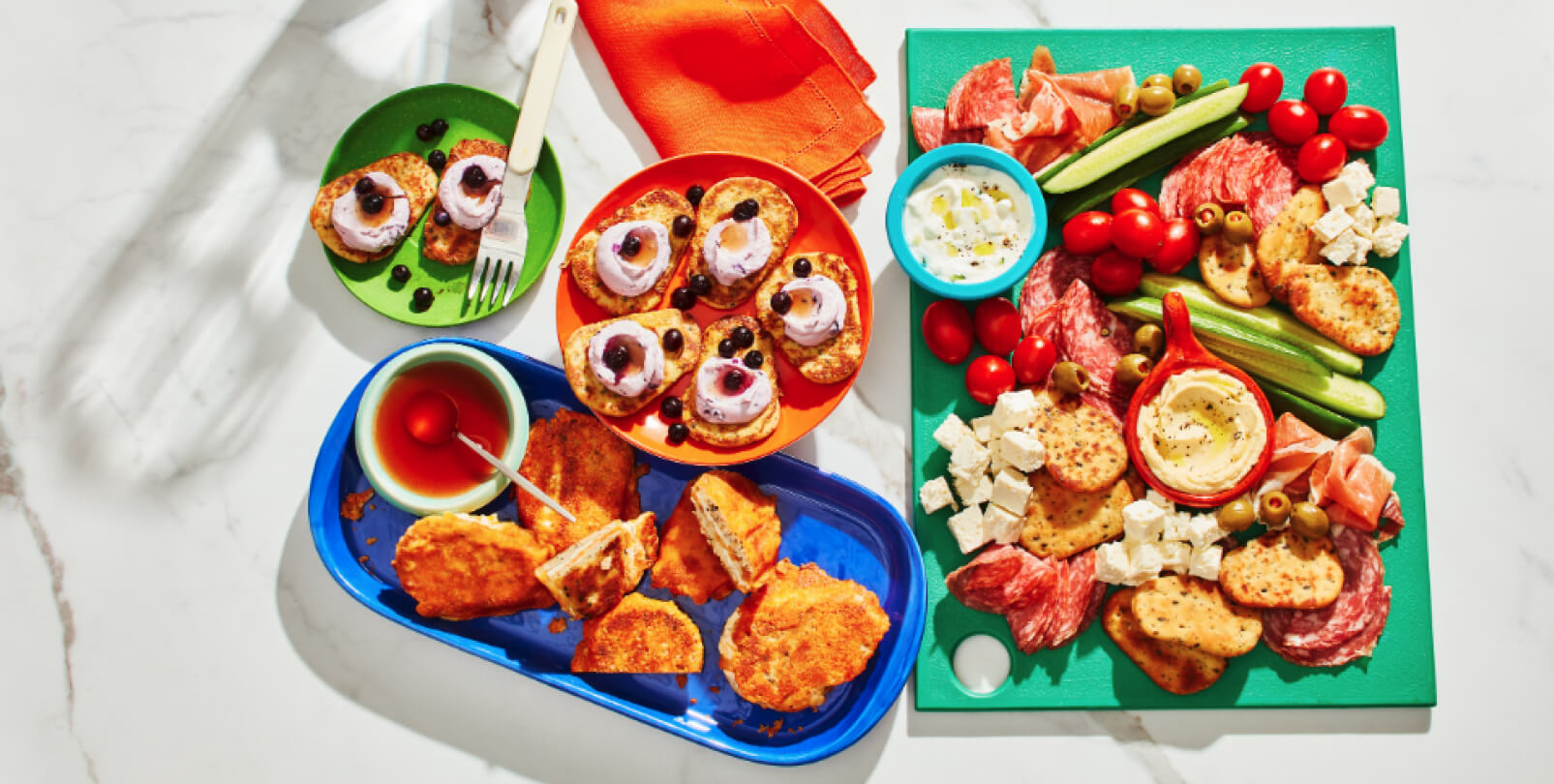 Mediterranean-style platter, french toast and cheese toasty on a white marble background