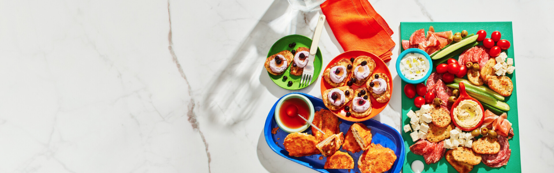 Mediterranean-style platter, french toast and cheese toasty on a white marble background